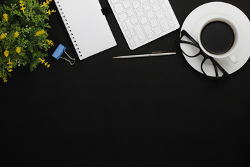 top view of coffee, notebook and office objects on black copy space background .