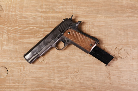 Weapon. Pistol on wooden background. Firearms for protection and secure.