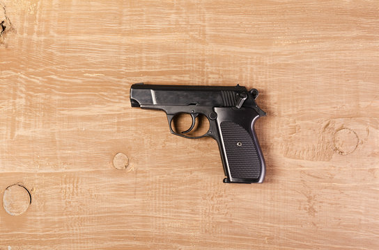 Weapon. Pistol on wooden background. Firearms for protection and secure.