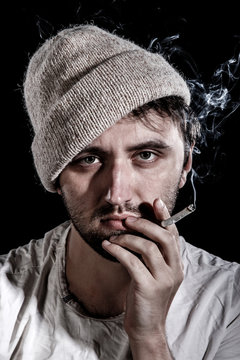 Unshaven man smoking a cigarette
