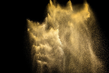 Golden sand explosion isolated on black background. Abstract sand cloud. Golden colored  sand...