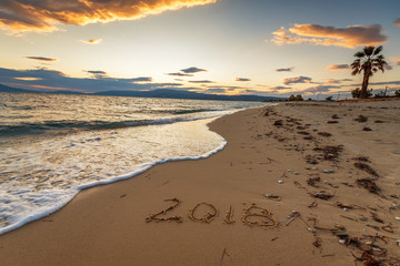 2018 written on the sand of a beach, travel 2018 new year concept.