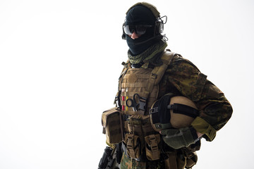 Fototapeta premium Portrait of serious soldier speaking by digital device while holding helmet in hand. Protection and conversation concept. Isolated and copy space