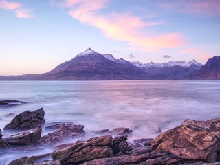 Rocks and boulders on shore.  Poor warm sunset light, smooth water.