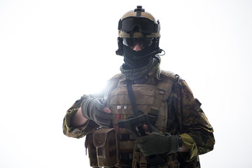 Fototapeta premium Portrait of serene defender holding assault rifle while looking at camera. Army concept. Isolated