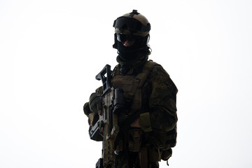 Portrait of serene peacemaker in military uniform holding assault rifle in hands. He looking at...