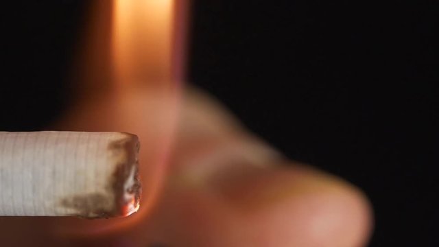 Ignite the lighter and light a cigarette. Close-up. High Dynamic Range. Slow motion