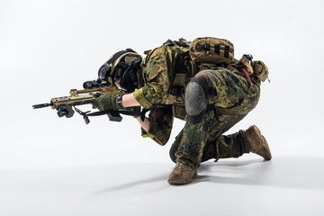 Full length severe soldier shooting firing with assault carbine. War concept