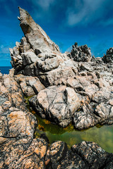Tormented rocks and green puddle on the coast of Ushant island, called ile d'Ouessant in french, in...
