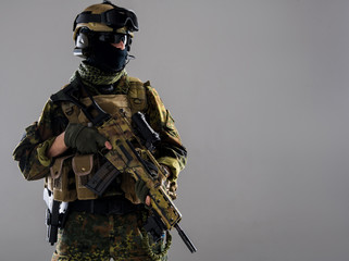 Portrait of grave male carrying on war while wearing uniform and keeping assault rifle. Protection concept. Copy space and isolated