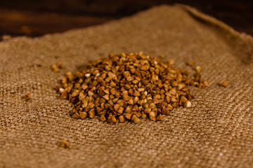 Pile of the raw buckwheat on sackcloth