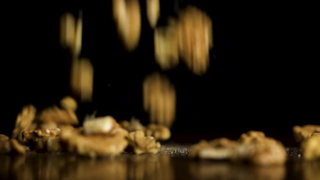 Healthy breakfast ingredients. Flying food. Walnuts are falling on black background