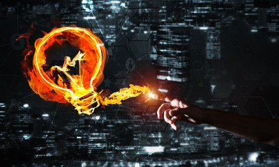 Concept of electricity or inspiration with burning light bulb on dark background