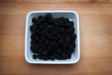 Blackberries in white bowl.