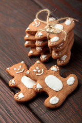 Stack of tiny gingerbread bears tied up with a lace with happy moods on a wooden table.Closeup