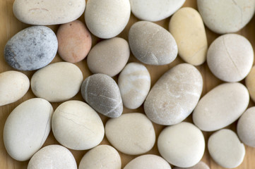 Fototapeta na wymiar Group of pebbles, light colors, stone background, round and smooth pebbles, simple and harmony texture