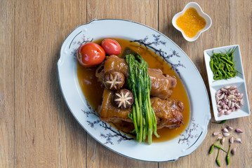 Stewed pork leg, red tomato, mushroom and Chinese kale in top view with copy space