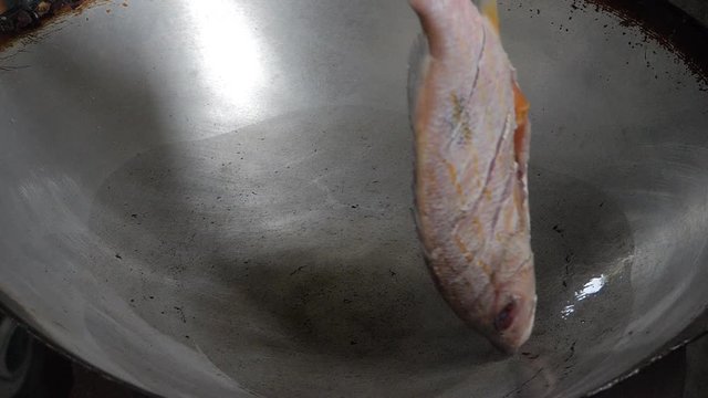 Snapper fish frying in pan with vegetable oil. cooking fried fish concept.
