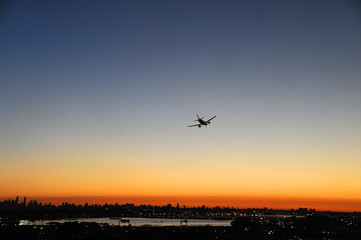 Fototapeta na wymiar airplane on the colorful sunset sky in New York