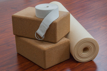 Stack of yoga equipment including yoga mat, strap, and cork blocks