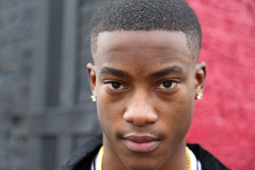 Close up face shot of a young Africa American male model against an abstract background