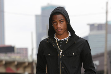 Street scene young African American male model against Dallas Texas skyline.