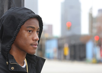 Street scene young African American male model wearing hoodie against Dallas Texas skyline. - obrazy, fototapety, plakaty