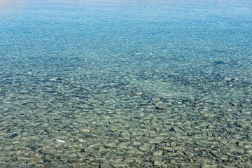 Closeup image of the stone under blue water in the lake