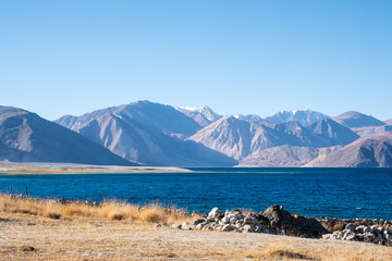 Landscape image of Pangong lake with mountains view and blue sky background