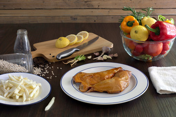 Prepare grill chicken with pepper and salt in white dish and ingredient in kitchen which has dim...