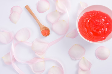 Spa accessories in Pink. Cream and pink rose flower petals on white background. Top view.