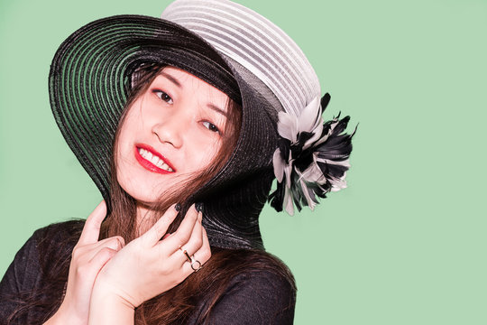 The portrait of a young oriental girl with a fashion hat