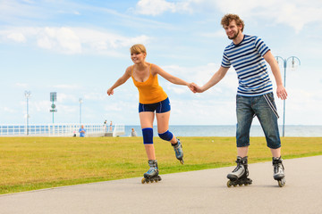 Young couple on roller skates riding outdoors