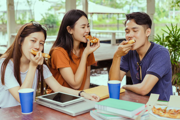 Asian group together eating pizza in breaking time having fun and enjoy party italian food slice with cheese delicious