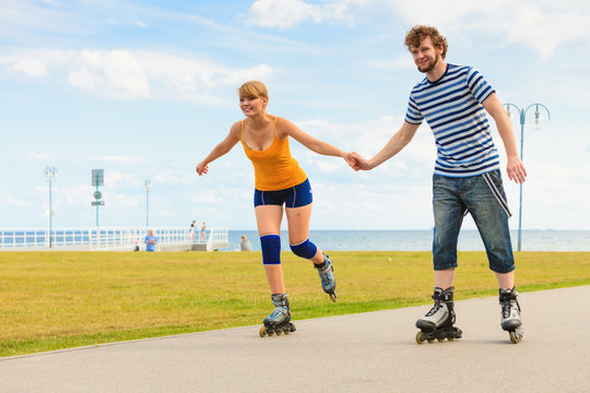 Young couple on roller skates riding outdoors