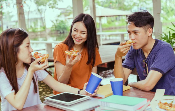 Asian group together eating pizza in breaking time having fun and enjoy party italian food slice with cheese delicious