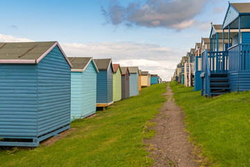 Fototapeta na wymiar Rows of beach huts on the North See coast at the Tankerton Slopes in Whitstable, Kent, England, UK