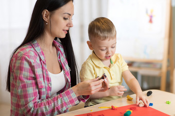 Fototapeta premium child kid boy and mother play colorful clay toy at nursery or kindergarten