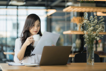 Young business woman using on the laptop while sitting at her working place.	