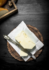 Butter with a knife on the board.