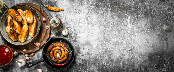 Various sausages in pans with garlic and spices.