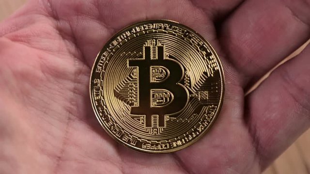 Man showing Bitcoin, close up of hands with BTC cryptocurrency coin
