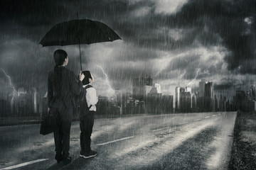 Businesswoman and her son looking at thunderstorm