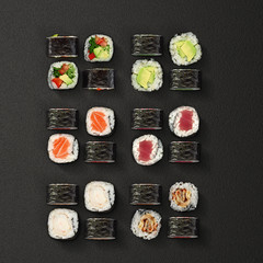 Japanese cuisine. Sushi rolls set over dark background.