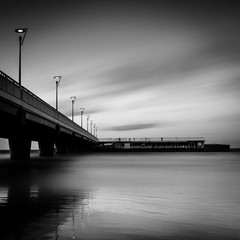 illuminated concrete pier in Kolobrzeg, long exposure shot at sunset in black and white