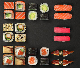 Japanese cuisine. Sushi and rolls set over dark background.