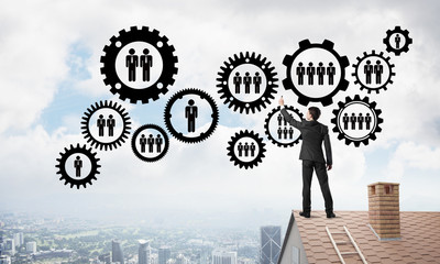 Businessman on house roof presenting teamwork and connection concept. Mixed media