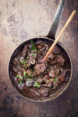 Fresh veal liver ragout in red wine sauce as top view in a casserole
