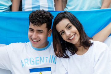 Lachende argentinische Fussball Fans mit Fahne