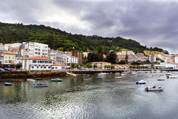 Fototapeta na wymiar View of the small town of Pontedeume in Galicia, Spain from the other side of the Eume estuary with a mountain behind very green and with a lot of vegetation